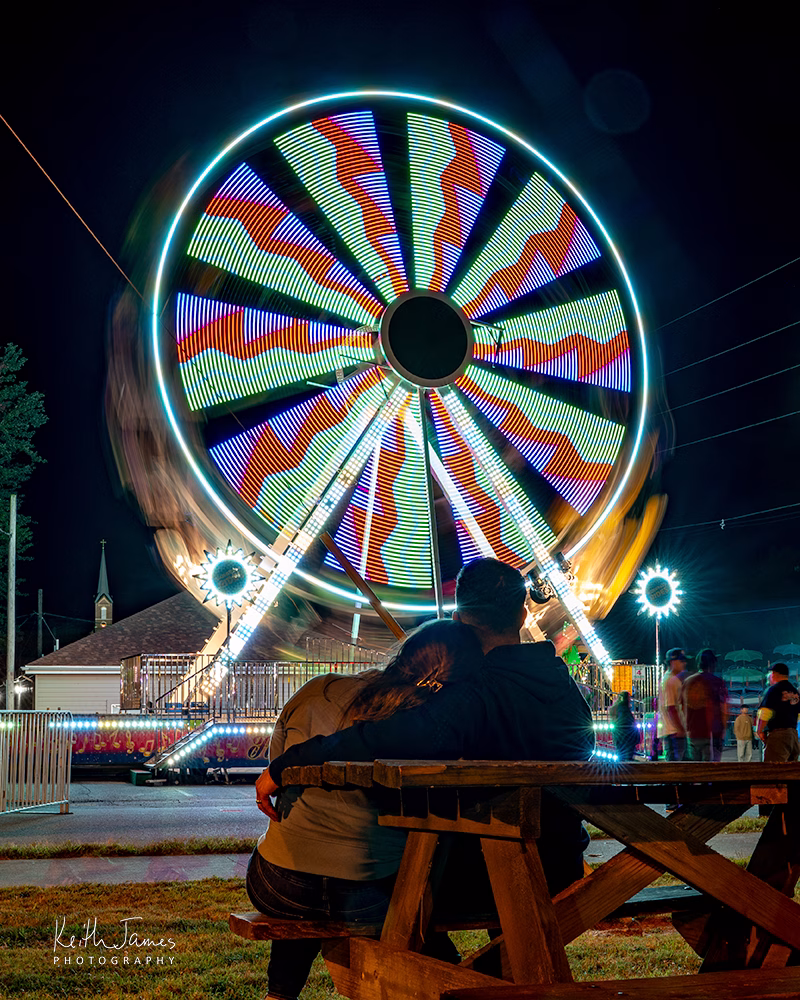 A couple enjoys the sight of a Ferris wheel in motion at Dale Fall Fest in Dale, Indiana