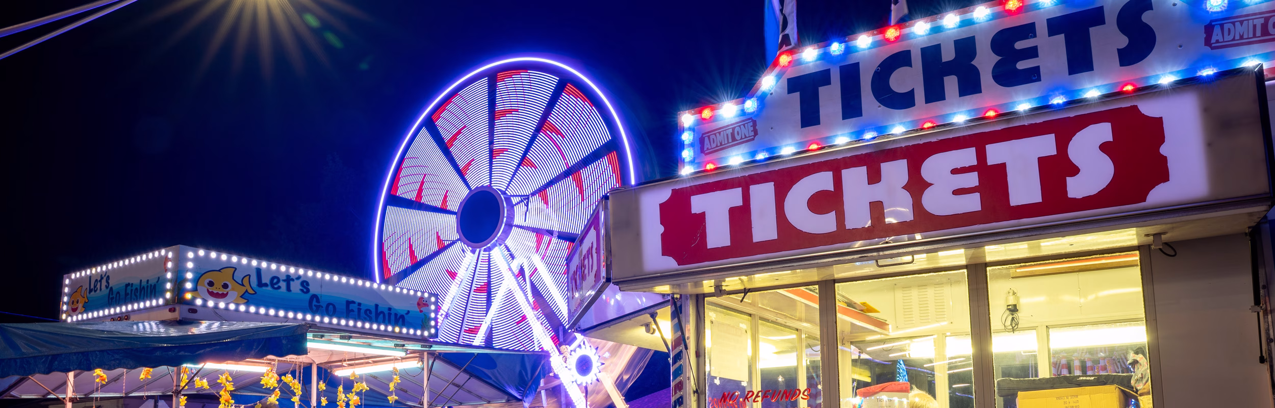 Ticket booths and a Ferris wheel in motion at Dale Fall Fest